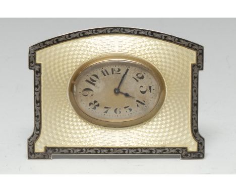 An Art Deco silver and guilloche enamel easel boudoir timepiece, 4.5cm oval silvered dial with Arabic numerals, on a yellow g