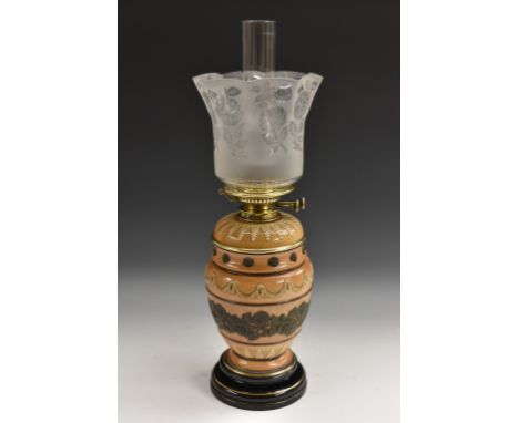 A Doulton Lambeth Silicone oil lamp, of ovoid form applied with flowers and foliage in olive on a buff ground, the shoulders 