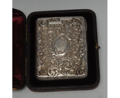 A Victorian silver rounded rectangular aide memoir, embossed with flowers and scrolling foliage, hinged cover enclosing a kid