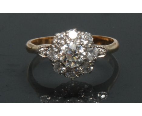 A diamond cluster ring, central round brilliant cut diamond approx 0.60ct, surrounded by a collar of eight smaller stone, all