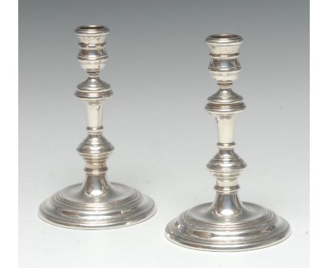 A pair of George I style silver table candlesticks, waisted sconces, knopped pillars, reeded circular bases, 17cm high, Mappi