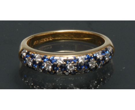 A sapphire and diamond eternity ring, the top crest inset with a checkered panel of thirty nine mixed round cut blue sapphire