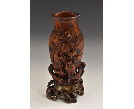 A Chinese soapstone flattened vase, boldly carved with a skirmish between a phoenix and a ferocious dragon, the ground incise