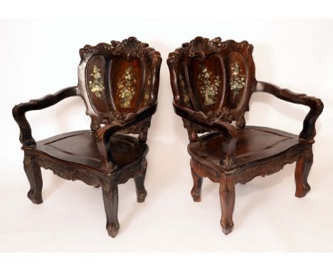 A pair of substantial Chinese hardwood armchairs, each cartouche shaped back crested by a boldly carved shell, and inlaid wit