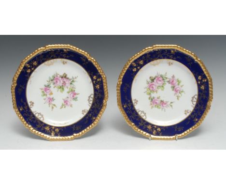 A pair of Royal Crown Derby shaped circular plates, painted by Charles Harris, one signed CH, with wreath of roses under a ra