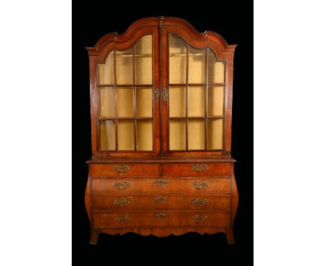 A substantial 19th century Dutch mahogany bookcase, shaped arched cresting above a pair of glazed doors, the projecting bombe