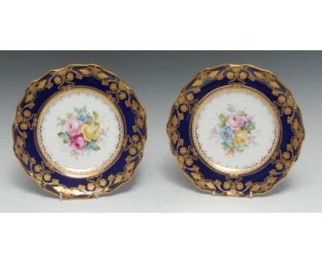 A fine pair of Royal Crown Derby shaped circular plates, painted by Cuthbert Gresley, signed with flowers under a raised gilt