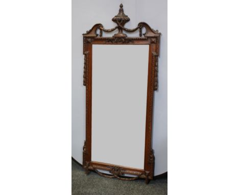 A pair George III Revival rectangular pier-glasses, each crested by a classical urn and a swag, rectangular mirror plates fla