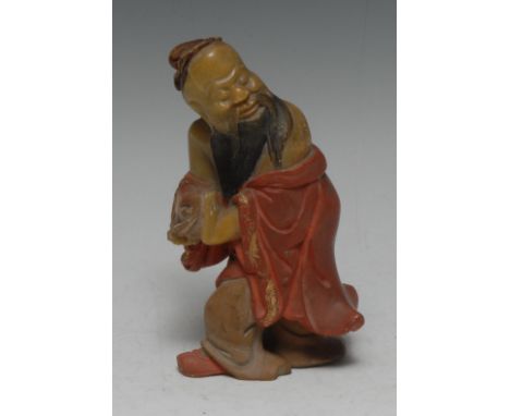 A Chinese soapstone carving, of Shou Lao, clutching the peach symbolic of longevity, wearing a flowing robe incised with scro