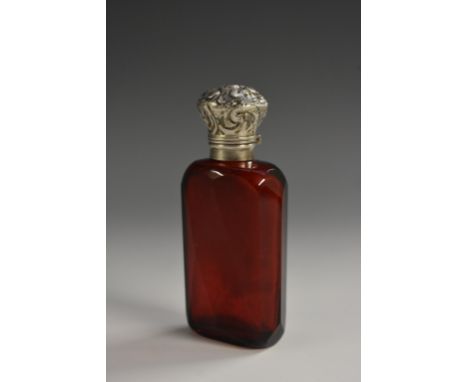 A 19th century silver coloured metal mounted ruby glass scent bottle, hinged domed cover chased with scrolling foliage, enclo