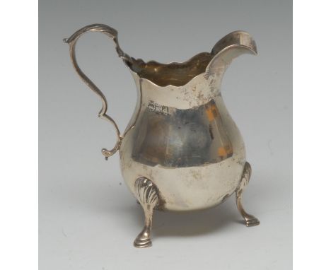 A Victorian silver bellied cream jug, of George II design, acanthus-capped double-scroll handle, hoof feet with shells to kne