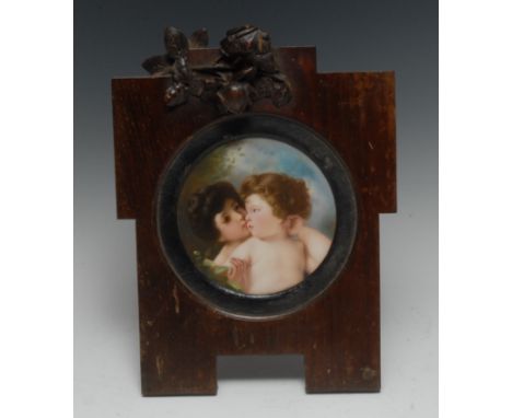 A German porcelain circular plaque, painted with a mother and her child, the background with a leafy foliage, 14cm diam, cont