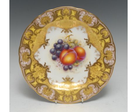 A Royal Worcester shaped circular cabinet plate, painted by John Freeman, signed, with ripe peaches and grapes, scrolling yel