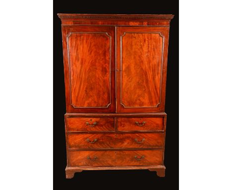 A George III mahogany linen press, dentil cornice above a pair of rectangular doors applied with re-entrant mouldings, the ba