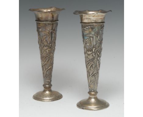 A pair of Art Nouveau silver trumpet shaped mantel vases, wavy rims, each embossed with irises, domed circular bases, 19cm hi