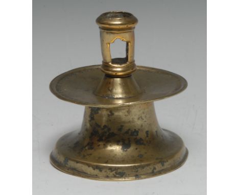 A 16th century Spanish brass capstan candlestick, pierced cylindrical sconce, broad slightly dished drip pan with a border of