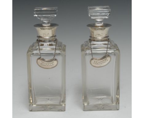 A pair of Art Deco silver mounted clear glass square spirit decanters, square stoppers, stepped shoulders, star-cut bases, 19