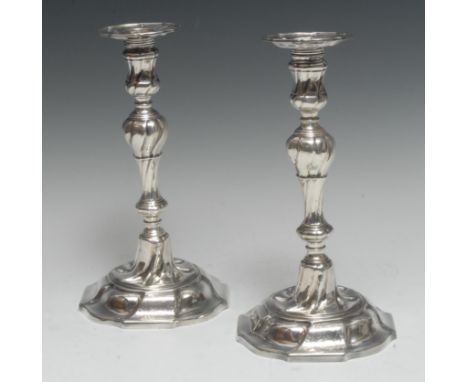 A pair of George II cast silver table candlesticks, spirally fluted knopped baluster pillars, detachable nozzles, domed shape