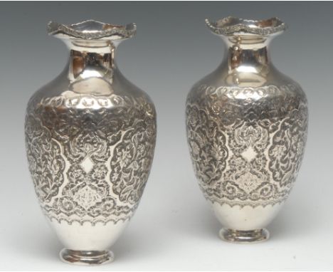 A pair of Persian Islamic silver ovoid vases, chased in the typical Qajar taste with birds amongst dense scrolling flowering 