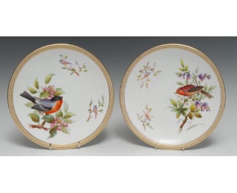A pair of Royal Worcester circular plates, painted with birds on blossoming branches, gilt and jewelled border, printed marks