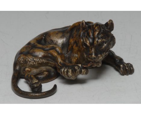 An Austrian cold painted bronze, of a lion cub, curled, with back paw raised for grooming, 13cm wide, c.1900 
