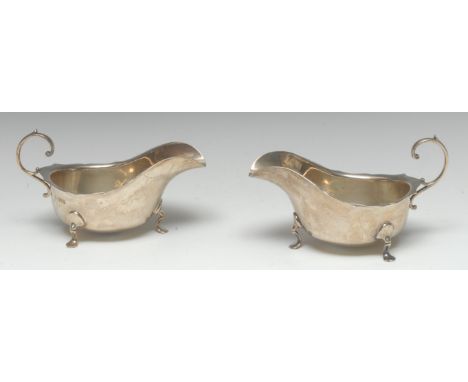 A pair of large Edwardian silver sauce boats, of George III design, flying-scroll handles, shaped everted rims, pad feet, 19.