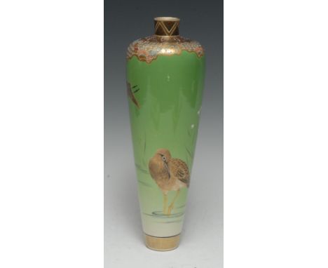 A Japanese slender ovoid vase, painted with wading bird, in tones of brown and black, picked out in gilt, on an apple green g