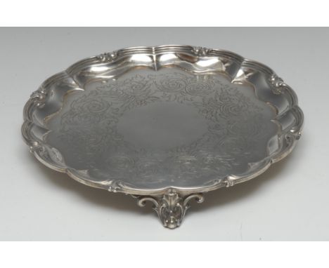 A William IV silver shaped circular salver, fluted leafy scroll border, the field engraved with a band of flowers and scrolli
