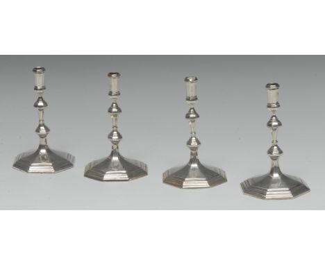 A set of four George I style cast silver octagonal tapersticks, knopped stems, spreading bases, 12cm high, Crighton &amp; Co 