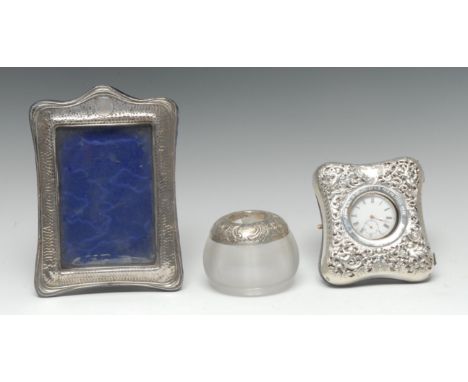 An Art Nouveau silver shaped rectangular easel photograph frame, planished overall and crested by a vacant circular cartouche
