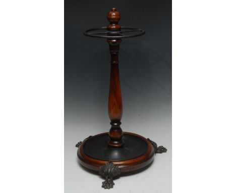 A Victorian mahogany circular stick/umbrella stand, three cast brass lion paw feet, 60cm, c.1880