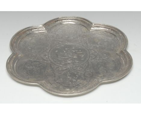 A Persian silver coloured metal lobed circular tray, profusely chased with figures smoking hookahs and engaged in daily life,