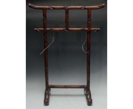 A Chinese hardwood rail, carved throughout with leafy bamboo shoots, two oversailing bar rails above two pilasters, scroll ca