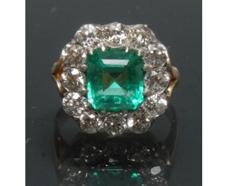 A Columbian emerald and diamond cluster ring, central certified Octagonal cut Columbian emerald, measuring 8.29mm x 8.05mm x 