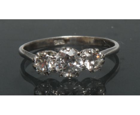 A diamond trilogy ring, central round brilliant cut diamond approx 0.60ct, flanker either side by a conforming smaller diamon