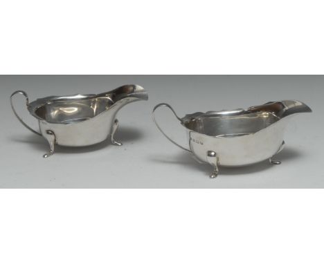 A matched pair of George V silver sauce boats, shaped everted rims, scroll handles, pad feet, Birmingham 1931 and Sheffield 1