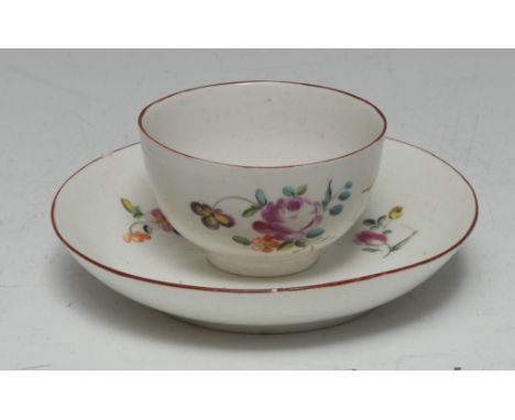 A Derby tea bowl and saucer, painted in polychrome enamels with scattered flowers and leafy foliage, iron red borders, the sa