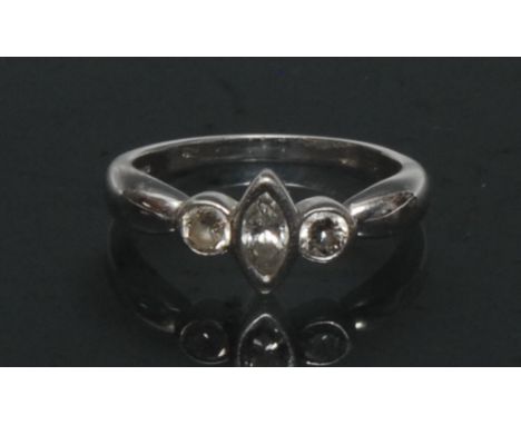 A modernist design diamond trilogy ring, central marquise cut diamond approx 0.22ct, flanked either side by a round brilliant