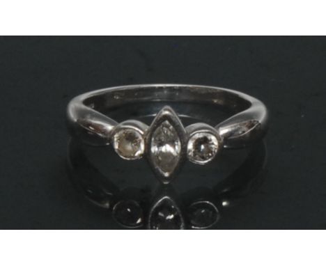 A modernist design diamond trilogy ring, central marquise cut diamond approx 0.22ct, flanked either side by a round brilliant