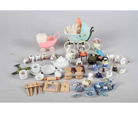 A collection of dolls house china, two early plastic prams, a 1930s Parisian model of a chair with a dog, and a companion, ch