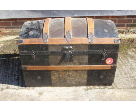 A domed top cabin trunk, 34" wide, a black metal uniform trunk, 35" wide, and two other metal trunks, one painted yellow 