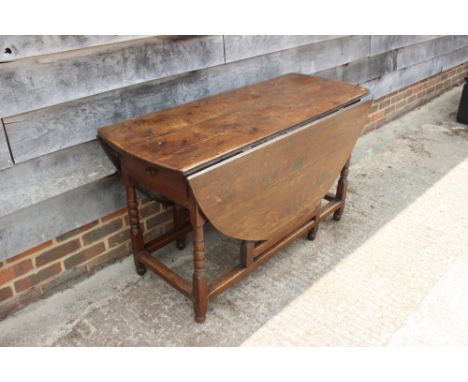 An oak gate leg table with bobbin turned, squared and stretchered supports, 50" wide 