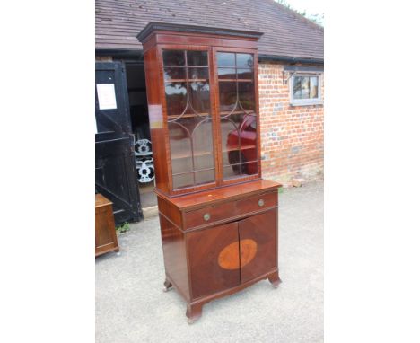 A mahogany and box line inlaid bookcase, the upper section enclosed lattice glazed doors over one drawer and cupboards, on sp