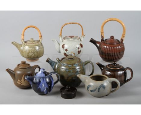 A studio pottery celadon glazed teapot with bamboo handle, two similar teapots and five other studio teapots 