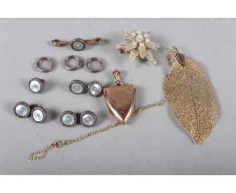 A 9ct gold shield-shaped locket, a 9ct gold fine link necklace, a set of mother-of-pearl dress studs and cufflinks, and a see