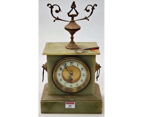 A circa 1900 onyx cased mantel clock, having enamelled chapter ring with Arabic numerals, the whole surmounted by a brass urn