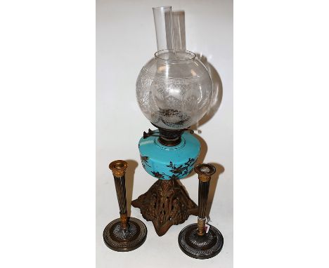 A late Victorian oil lamp, having etched globular glass shade above a blue porcelain reservoir, with transfer printed decorat