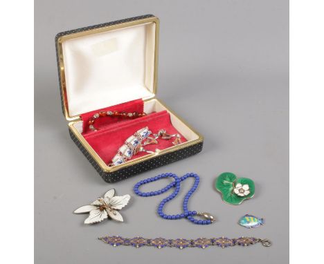 A hinged jewellery box containing various items of modern jewellery; including Lapiz Lazuli beads, silver jewellery and Norwe