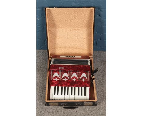 A cased Amigo accordion with red marbled effect body.  