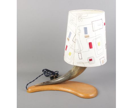 A vintage horn table lamp on curved wooden base.  